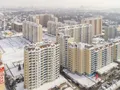 На переднем плане (слева направо) корпуса 102 и 100 (стоит углом). На первом этаже - магазины. Аэрофотосъемка от 03.03.2018 г.